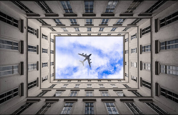Jet airplane passing on cluod sky in a big city