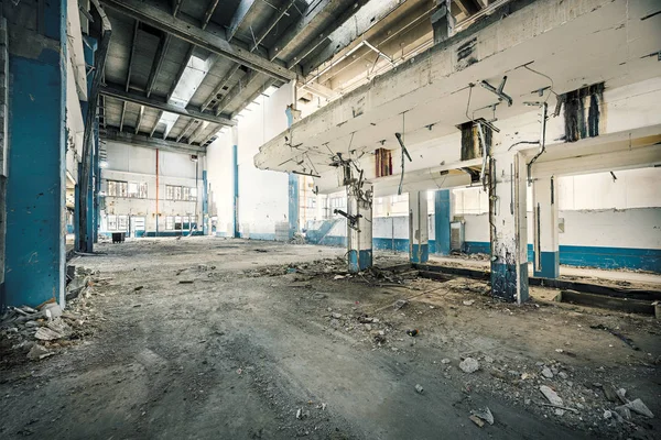 Interior da indústria abandonada com sujeira e desbastes enferrujados Imagem De Stock