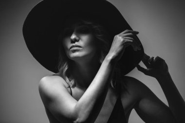 Beautiful portrait of a woman in a big hat. Studio. Close-up.