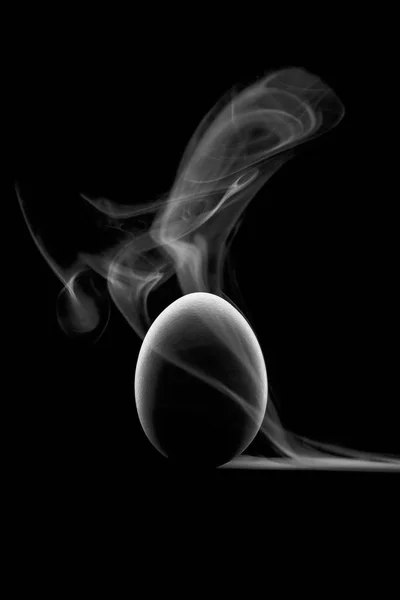 El contorno de los huevos sobre un fondo negro y vapor blanco o humo . —  Fotos de Stock