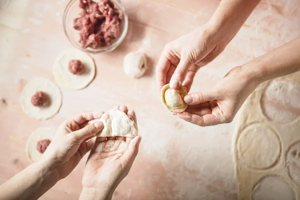 Aile eğlencesi. Mans eller ravioli için hamur hazırlıyor, tortellin ise klasik tonlama..