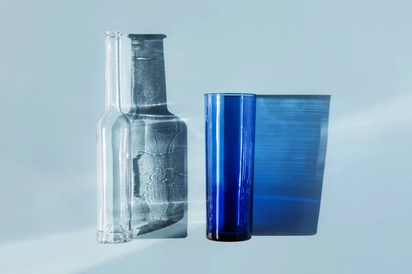 Glass bottle and glass and their shadow. — Stock Photo, Image