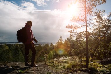 Arka planda kamera ve sırt çantası olan bir gezgin..