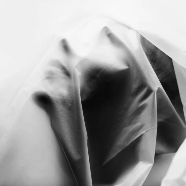 女性の顔は白い半透明のセロファンで覆われています。. — ストック写真