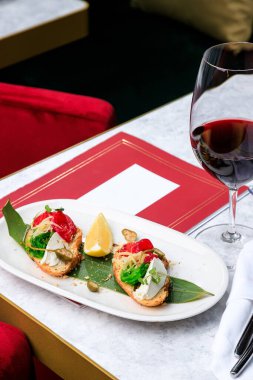 Somon, peynir ve yosunlu kızarmış bruschetta. Bir kadeh kırmızı şarap. Metin için yer.