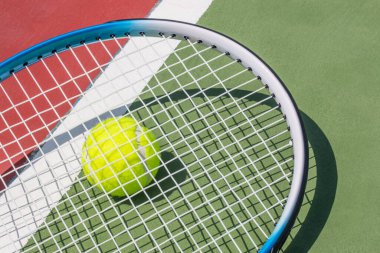 Tenis raketi ve tenis topunun korttaki fotoğrafı.