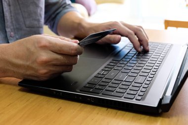 Erkekler online alışveriş siparişi vermek için kredi kartı ve ödeme bilgilerini klavyede tutuyorlar. İnternet teknolojisi ve Dijital Pazar yeri E-Ticaret yaşam tarzı konsepti, Satın Alma işlemi.