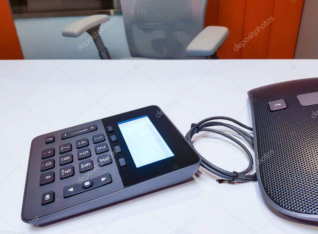 Business conference phone set up in the meeting room. Communication technology for voice conference meeting for long distance office or workplace. With number keypad.