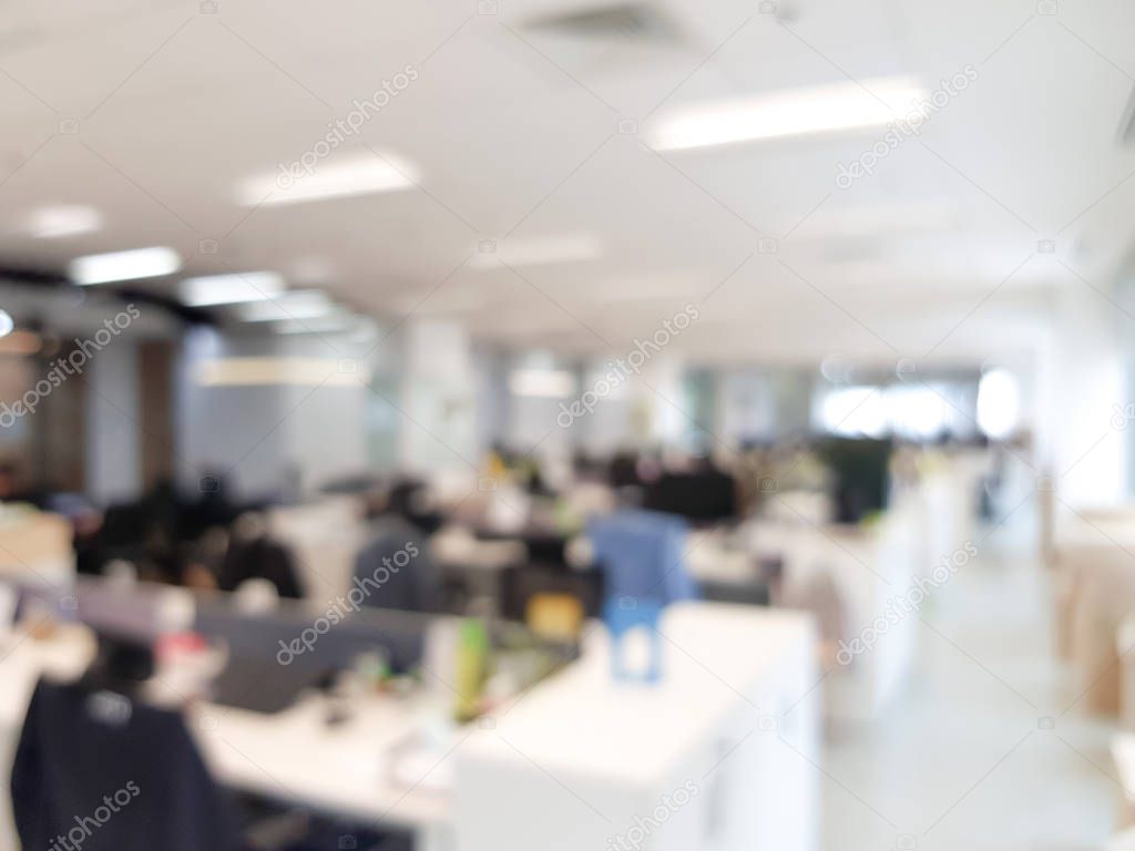 Blurred interior of modern office workplace a workspace design without partition decorate with black, white and wooden furniture. Nice environment can create work productivity, relax mood.