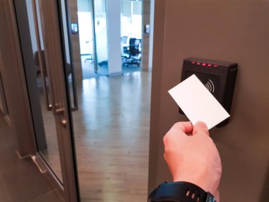 Erkekler ofis alanına girmek için RFID anahtar kartını kullanıyorlar. Bina güvenliğinde sadece yetkili kişi
