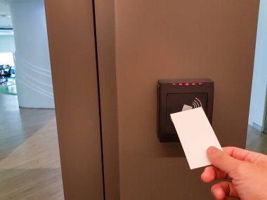 Erkekler ofis alanına girmek için RFID anahtar kartını kullanıyorlar. Bina güvenliğinde sadece yetkili kişi