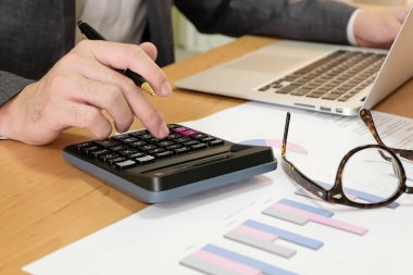 Bulanık odaklı, takım elbiseli zeki iş adamı mali, vergi ve iş bilgisi grafikleri grafiği grafiği grafiği grafiği çiziyor. Kişisel ve kurumsal konsept için vergi ve gider tasarrufu.