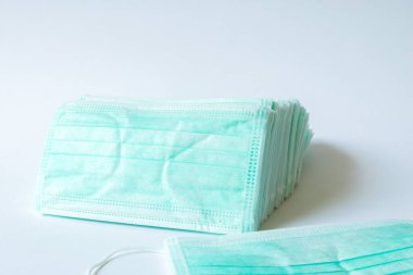 Grip ve diğer hastalıklara karşı korunmak için yeşil renkli tıbbi maske. Cerrahi koruyucu maske. Beyaz arka planda tıbbi solunum bandajı var. Virüsün yayılmasının önlenmesi