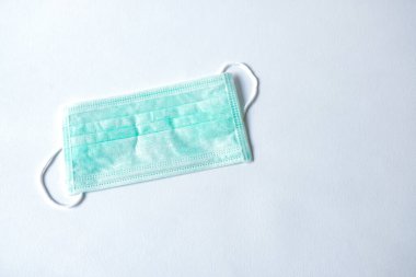 Grip ve diğer hastalıklara karşı korunmak için yeşil renkli tıbbi maske. Cerrahi koruyucu maske. Beyaz arka planda tıbbi solunum bandajı var. Virüsün yayılmasının önlenmesi