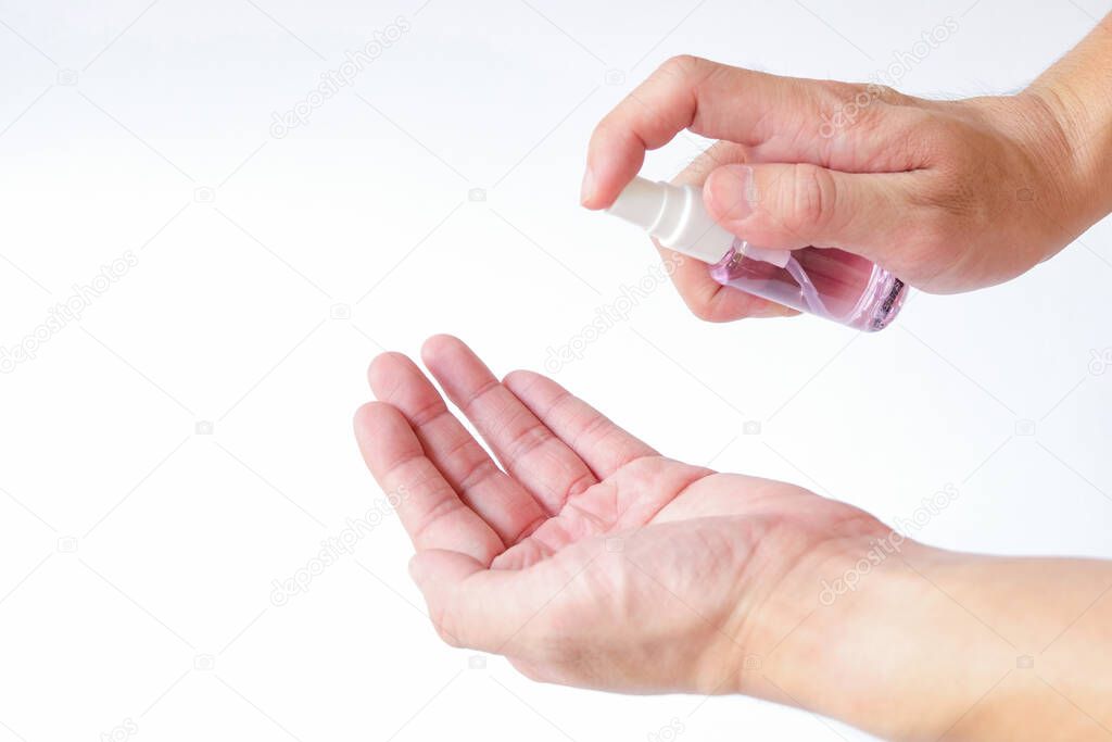Selective focus of Asian men hand using Alcohol spray, hand sanitizer for personal hygiene on white background to protect, prevent from virus and illness during Corona virus outbreak or Covid 2019.
