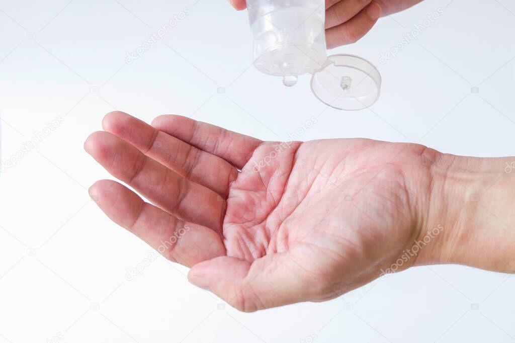 Selective focus of Asian men hand using Alcohol gel, hand sanitizer for personal hygiene on white background to protect, prevent from virus and illness during Corona virus outbreak or Covid 2019.