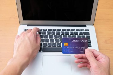 Erkekler online alışveriş siparişi vermek için kredi kartı ve ödeme bilgilerini klavyede tutuyorlar. İnternet teknolojisi ve Dijital Pazar yeri E-Ticaret yaşam tarzı konsepti, Satın Alma işlemi.