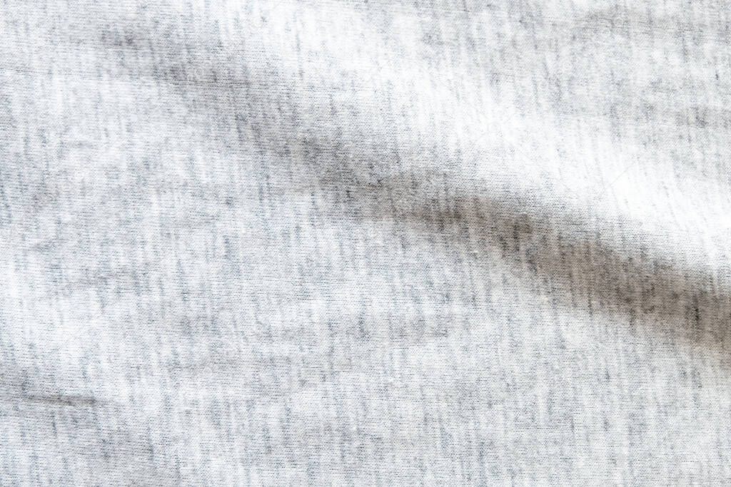 Close up shot to see the detail of heather grey knitted fabric made of synthetic fibres background. abstract wallpaper clothing or soft textile with copy space for text.