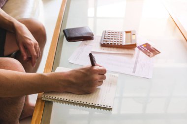 Hesap makinesi kullanan, fatura tutan ve maaşını kişisel gider bütçesi için kontrol eden seçici erkekler. Tasarruf ve ödeme denetimi için bireysel bilanço. Mali ve ekonomi kavramı.