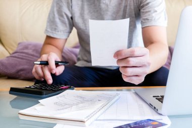 Hesap makinesi kullanan, fatura tutan ve maaşını kişisel gider bütçesi için kontrol eden seçici erkekler. Tasarruf ve ödeme denetimi için bireysel bilanço. Mali ve ekonomi kavramı.