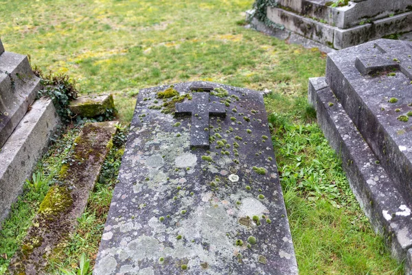 Old grey cross on tomb at cemetery — Zdjęcie stockowe