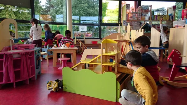 Crianças brincando com brinquedos no quarto. dois meninos brinca com garagem de carro de madeira — Fotografia de Stock