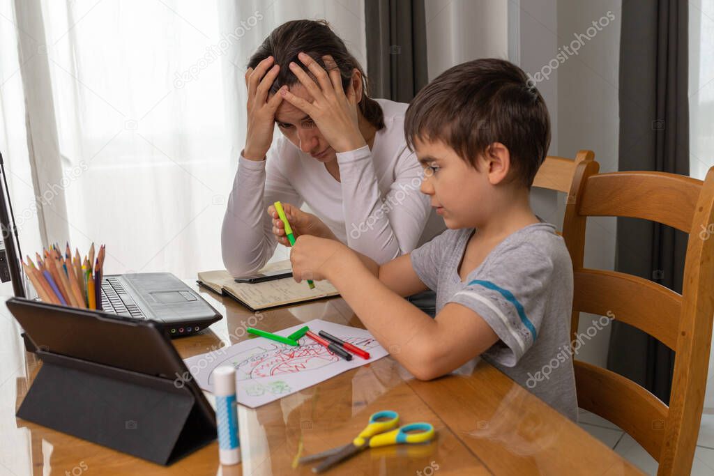 Mother helping her son to do homework, home school education, small boy learning at home remotely