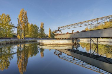 Duisburg - Landschaftspark Duisburg-Meiderich 'teki su rezervuarına bakın. Ağaçlar suya yansıyor, Kuzey Ren Vestfalyası, Almanya, Duisburg, 03.11.2018