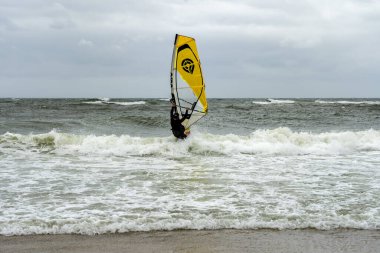 Sylt - Almanya 'nın kuzeyinde Schleswig-Holstein eyâletinde, Wenningstedt Sahili' nde dalgalı deniz içinde rüzgar sörfçüsüne yakın çekim