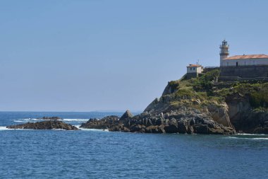 Deniz feneri ve uçurumu olan okyanus kıyısı, doğanın renkleri
