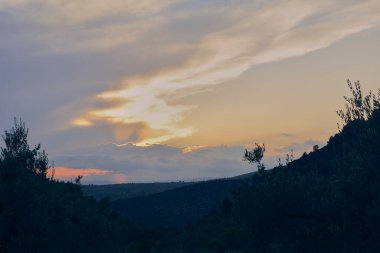 Ormanlı dağlık arazide gün batımı. Doğanın renkleri