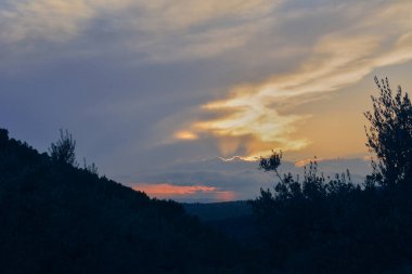 Ormanlı dağlık arazide gün batımı. Doğanın renkleri