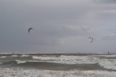 Fırtınalı bir günde birkaç kişi kayak yapıyor, doğanın renkleri.