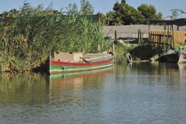 Gölde seyrüsefer bekleyen üç tekne var. Doğanın renkleri
