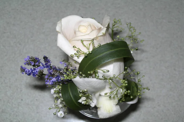 Ozdoba Wykonana Białego Kwiatu Zielona Gałąź Niebieski Kwiat Szarym Tłem — Zdjęcie stockowe