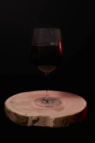 Copa Vino Tinto Sobre Tronco Madera Sobre Fondo Negro — Foto de Stock