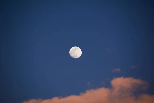 Full moon in blue sky with clouds, cotton sunset