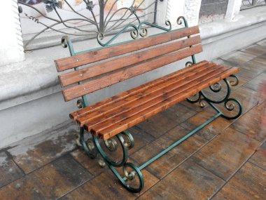 Güzel ahşap bir bankta dövülmüş bacaklarda Şehir sokaklarında yağmurda