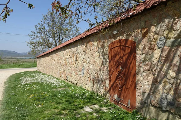 Eine Mauer Aus Steinblöcken Mit Einer Roten Metalltür Und Davor — Stockfoto