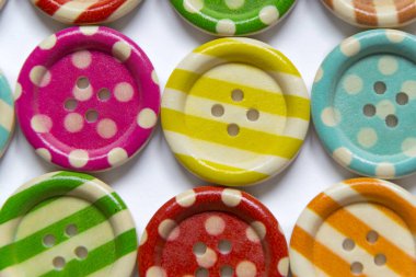 Beyaz arkaplandaki çeşitli renkli dikiş düğmelerinin tam kare fotoğrafı. Yüksek açı görünümü