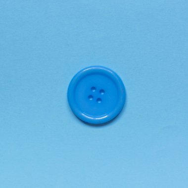 Mavi arkaplanda tek mavi dikiş düğmesi.