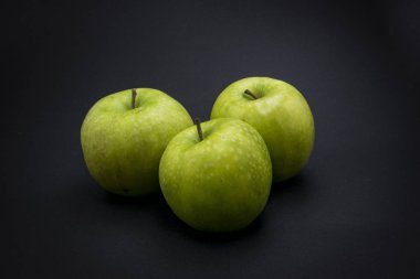 Siyah arkaplanda yeşil elma.