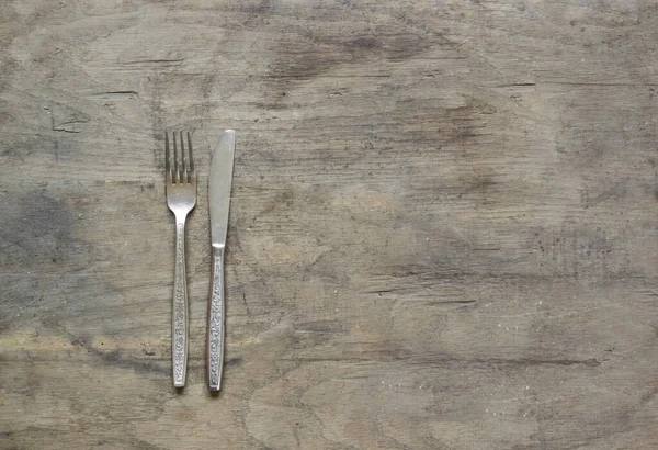 錆びた 木製の背景にシルバーフォークとナイフ — ストック写真