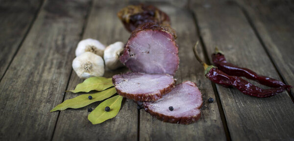 Сушеная свинина с перцем чили, черным перцем, чесноком и лавровыми листьями на старом деревянном столе
