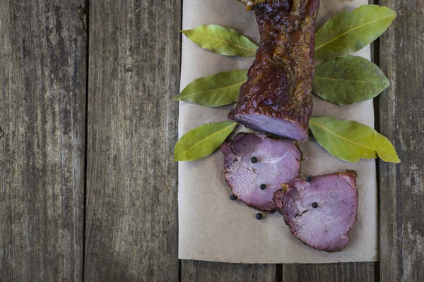 Сушеная свинина с перцем чили, черным перцем, чесноком и лавровыми листьями на старом деревянном столе. Вид под высоким углом, с пространством для текста
.