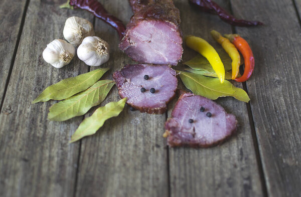 Сушеная свинина с перцем чили, черным перцем, чесноком и лавровыми листьями на старом деревянном столе
