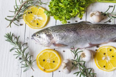 Maydanozlu, sarımsaklı ve biberiyeli taze alabalık. Lezzetli balıklar yemek için hazırlanır. Üst açı görünümü