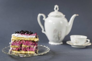 Mavi arka planda bir fincan çaylı yaban mersinli kek..