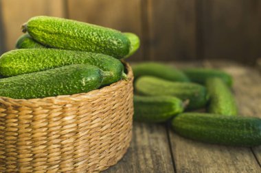 Taze salatalıklar kutuda ve eski ahşap masada. Seçici odak