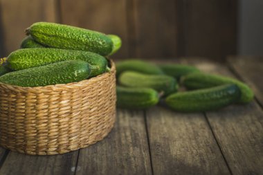 Taze salatalıklar kutuda ve eski ahşap masada. Seçici odak